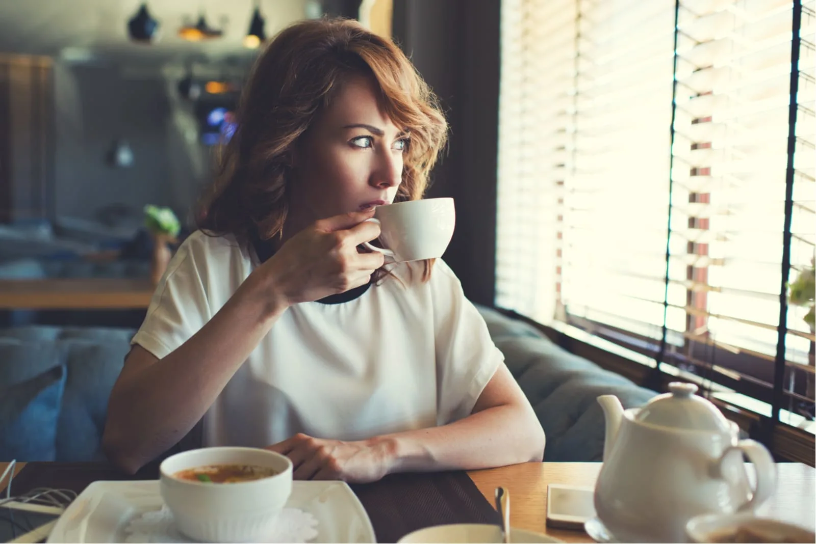 woman sitting in cafe drinking coffee