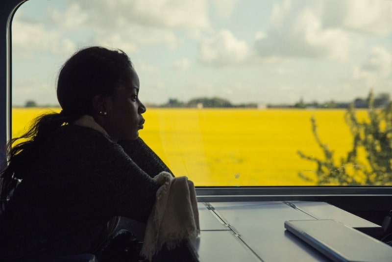 mujer sentada en un tren cerca de una ventana