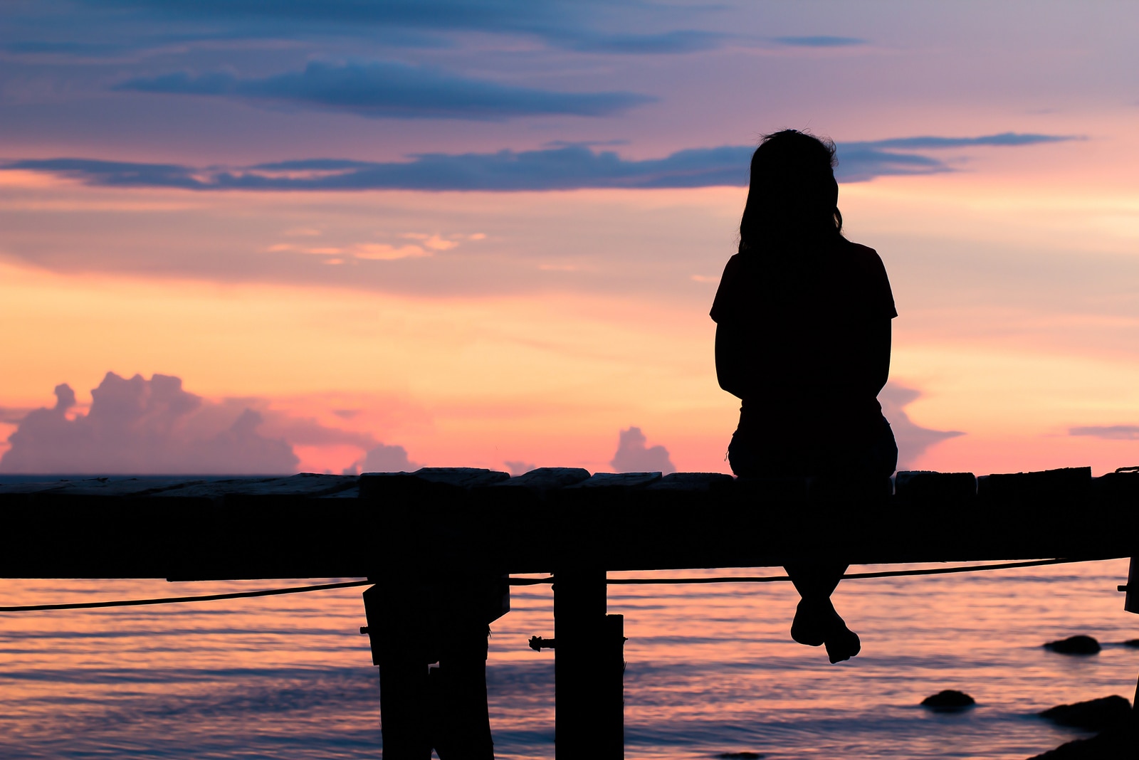 woman sitting on a wooden bridge