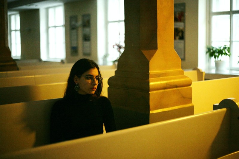 woman in black top sitting on bench indoor