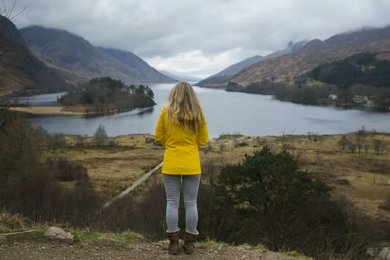 woman in yellow jacket standing near water