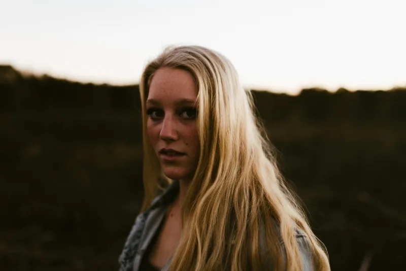 blonde woman standing outdoor during sunset