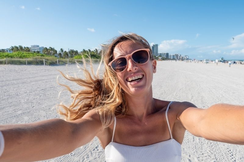 donna che si scatta un selfie godendosi la spiaggia durante il giorno