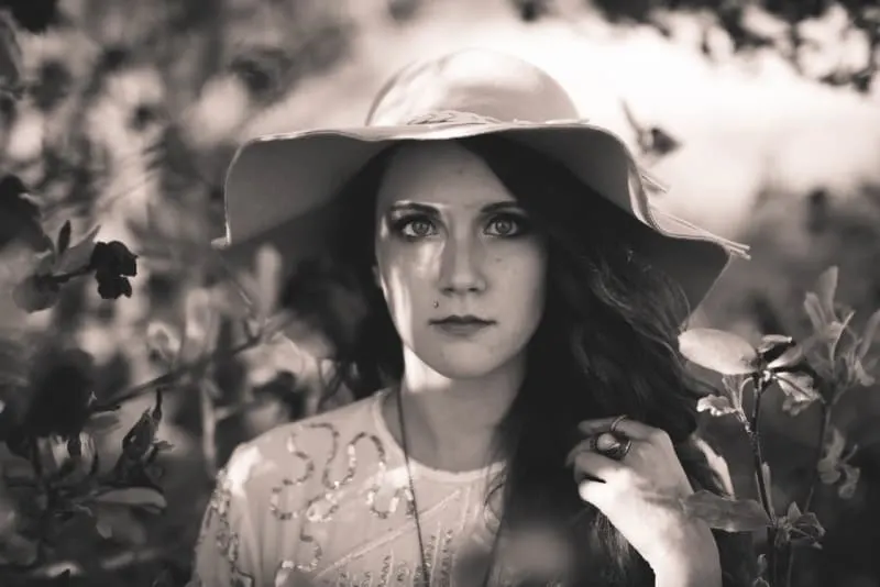 woman with hat touching her hair outdoor