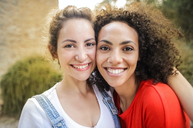 two smiling women hugging outdoor