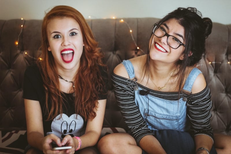two smiling women sitting on couch