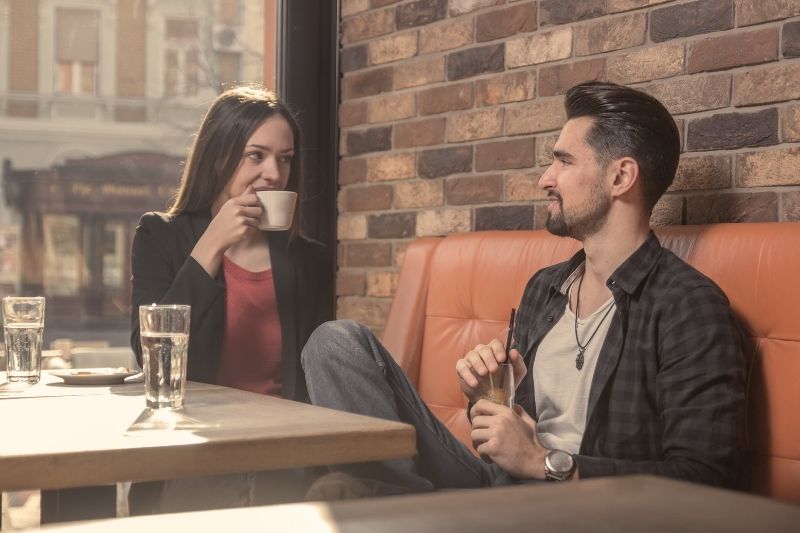 giovane uomo e donna che parlano nel caffè 