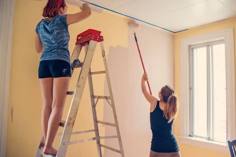 young women painting on the wall of the room