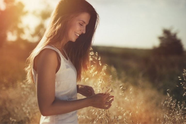 hermosa mujer despreocupada de pie en el campo siendo feliz