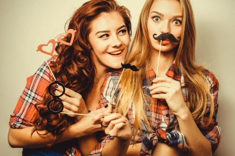 two beautiful hipster friends making fun with the maskara