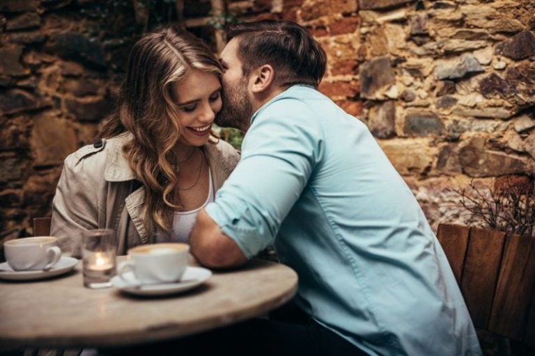 man whispering something to the woman's ear during a date night