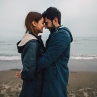 homem e mulher abraçados junto ao mar