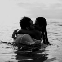 man and woman kissing while standing in water