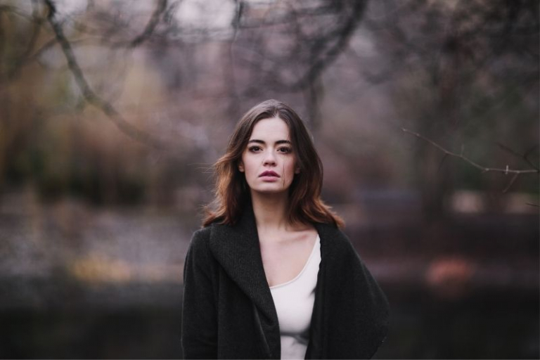 pensive young woman walking at the park