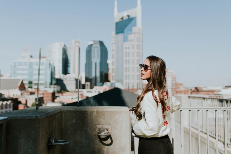 mujer con gafas de sol cerca de la barandilla