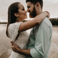 man and woman hugging while standing near water