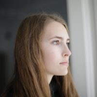 pensive woman looking through window