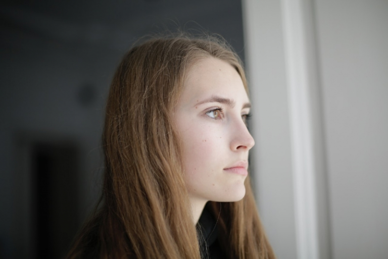 mujer pensativa mirando por la ventana