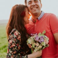 happy woman with bouquet hugging man outdoor