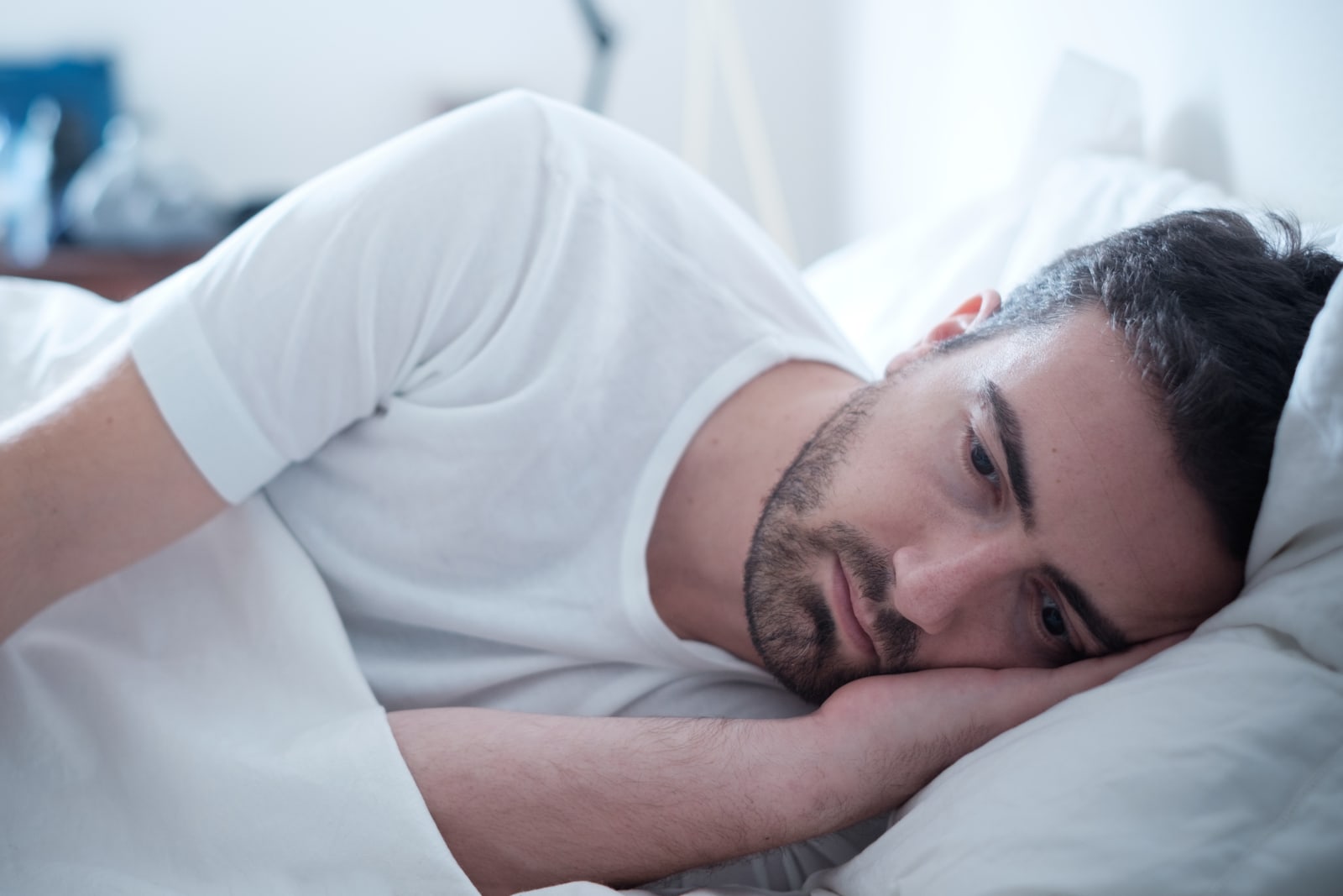 a lonely man lying in bed