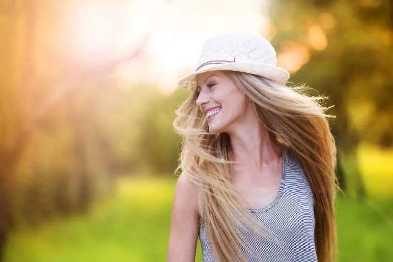 attractive young woman enjoying life under the sun with hat
