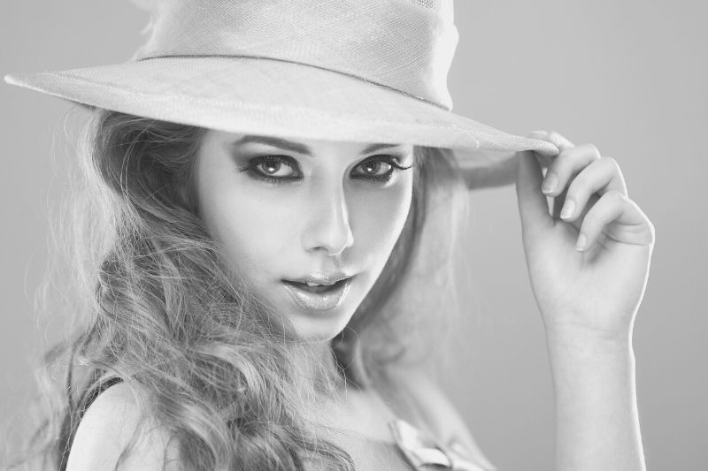 beautiful model posing wearing a hat in grayscale photography