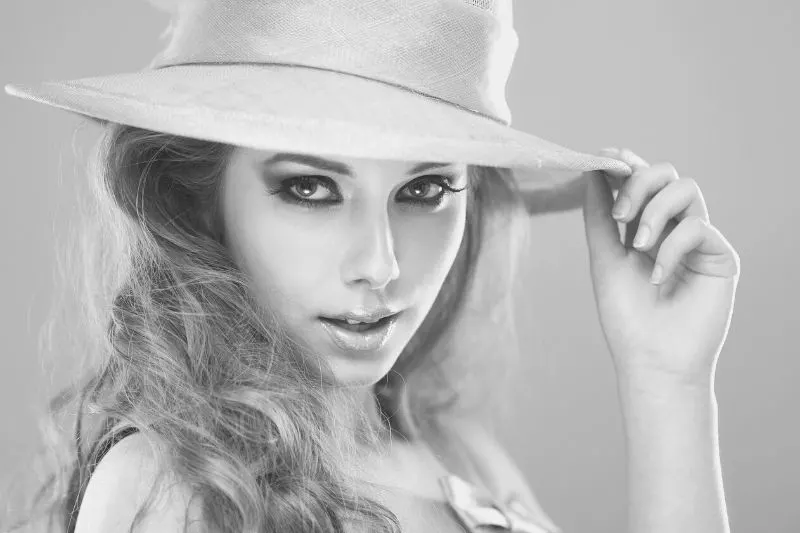 beautiful model posing wearing a hat in grayscale photography