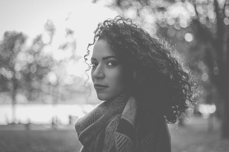 black and white photography of a curly haired woman looking at the camera