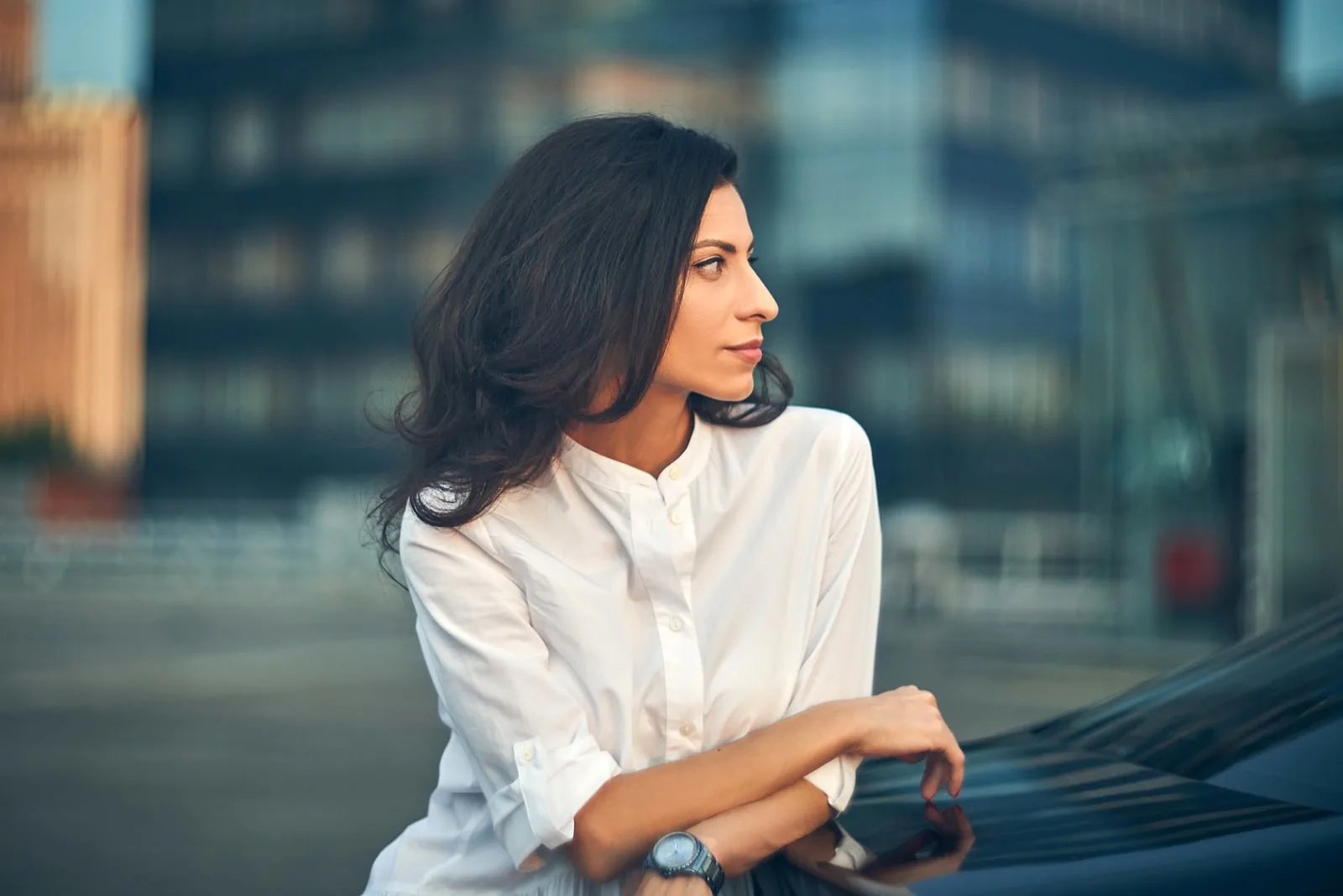 business woman standing outdoors leaning on the car