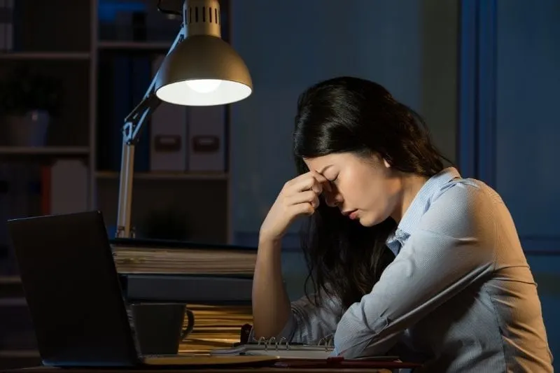 business woman suffering from headache doing overtime at the office