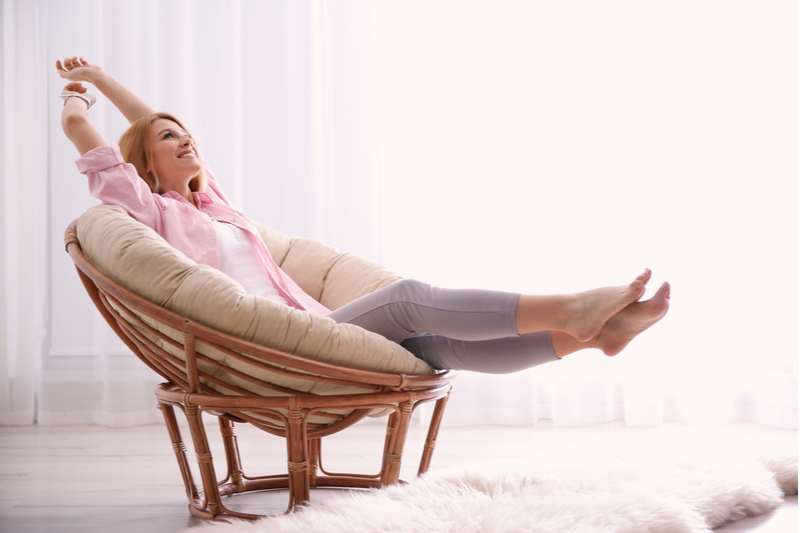 caucasian woman relaxing at the couch alone inside a cozy room 