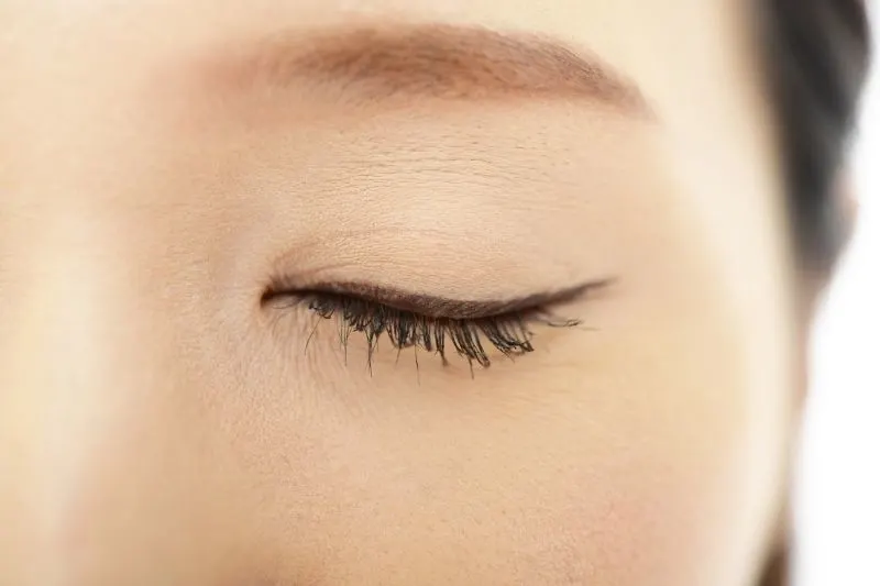 close up focus of a closed eye of an asian woman