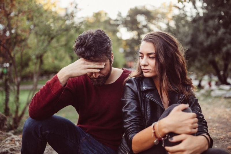 couple breaking up in the park feeling disappointed