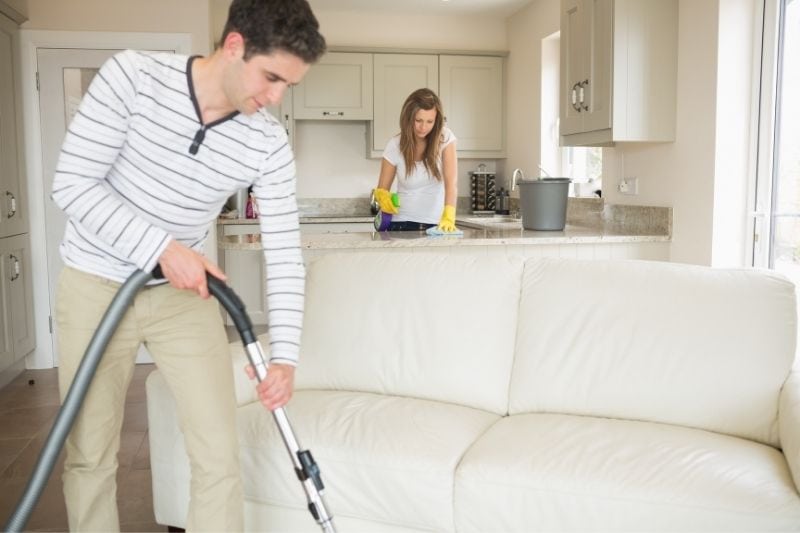 pareja limpiando la casa juntos durante el día