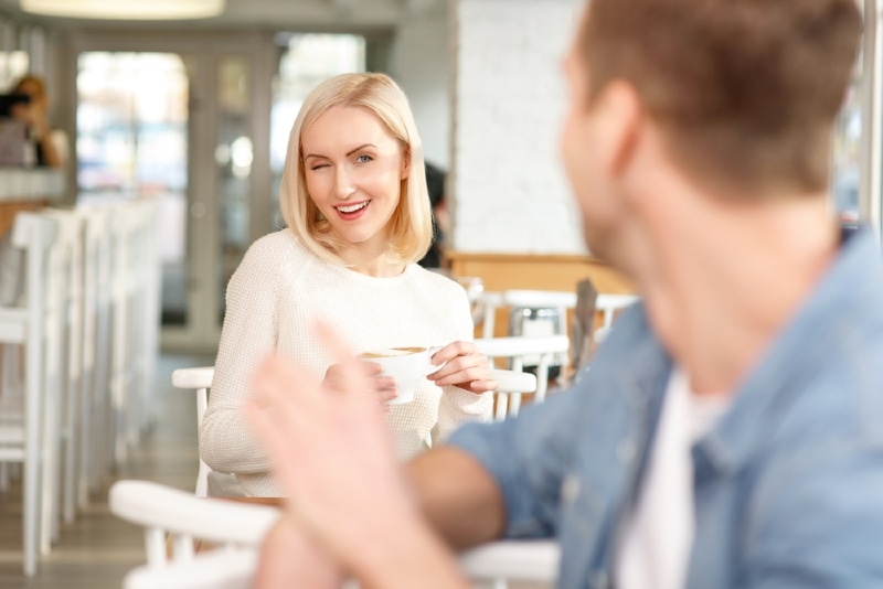 man and woman flirting in cafe