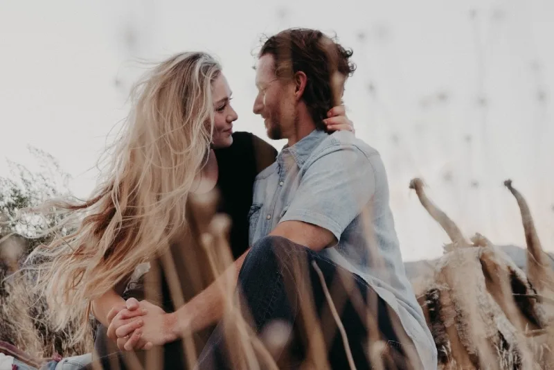 man and woman holding hands while sitting outdoor