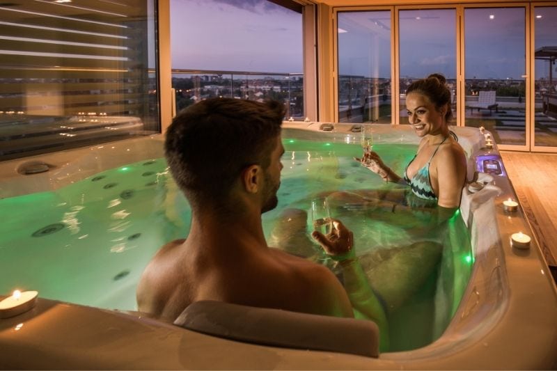  couple à l'intérieur de la baignoire buvant du vin à l'intérieur de l'hôtel 