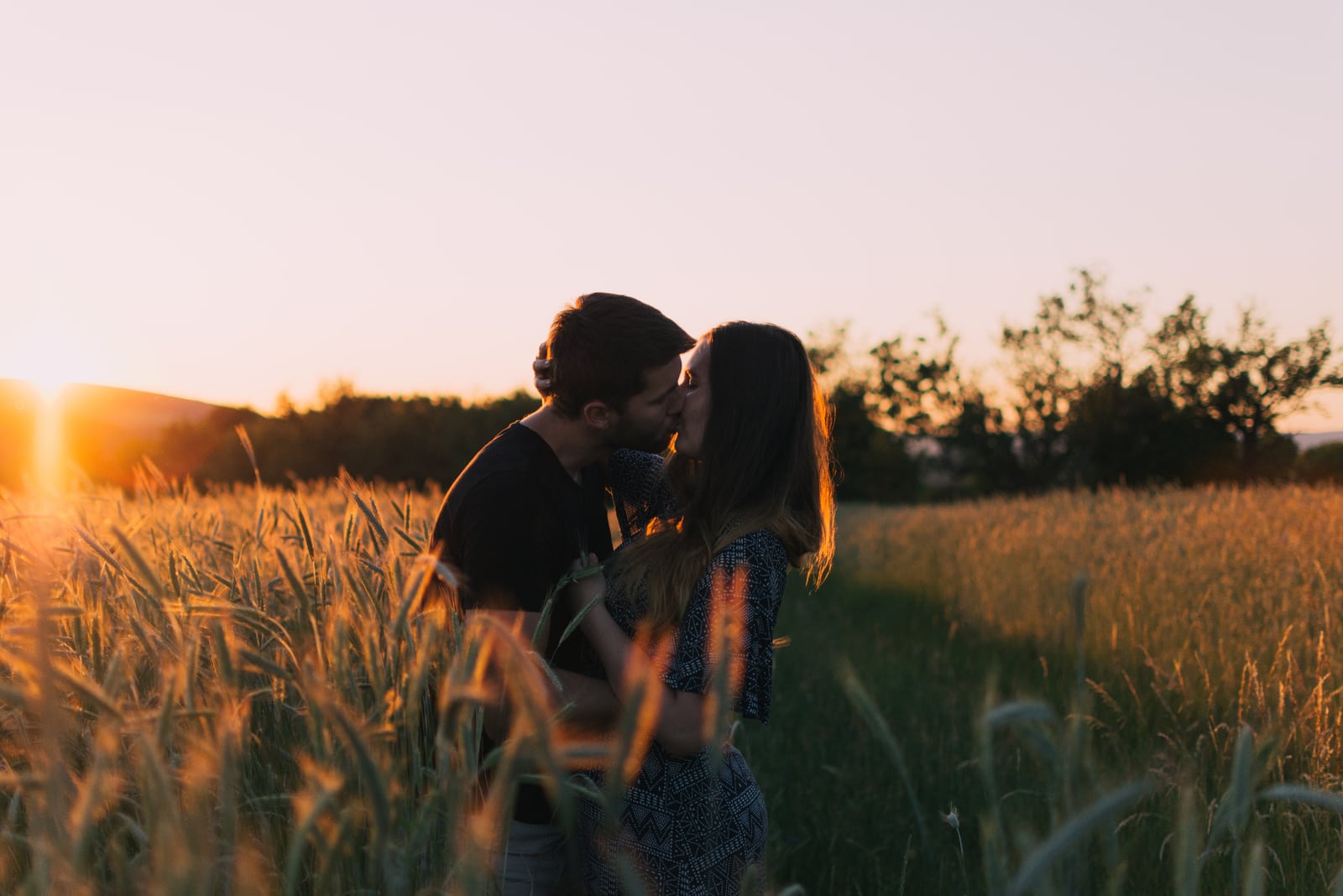 couple kissing in field