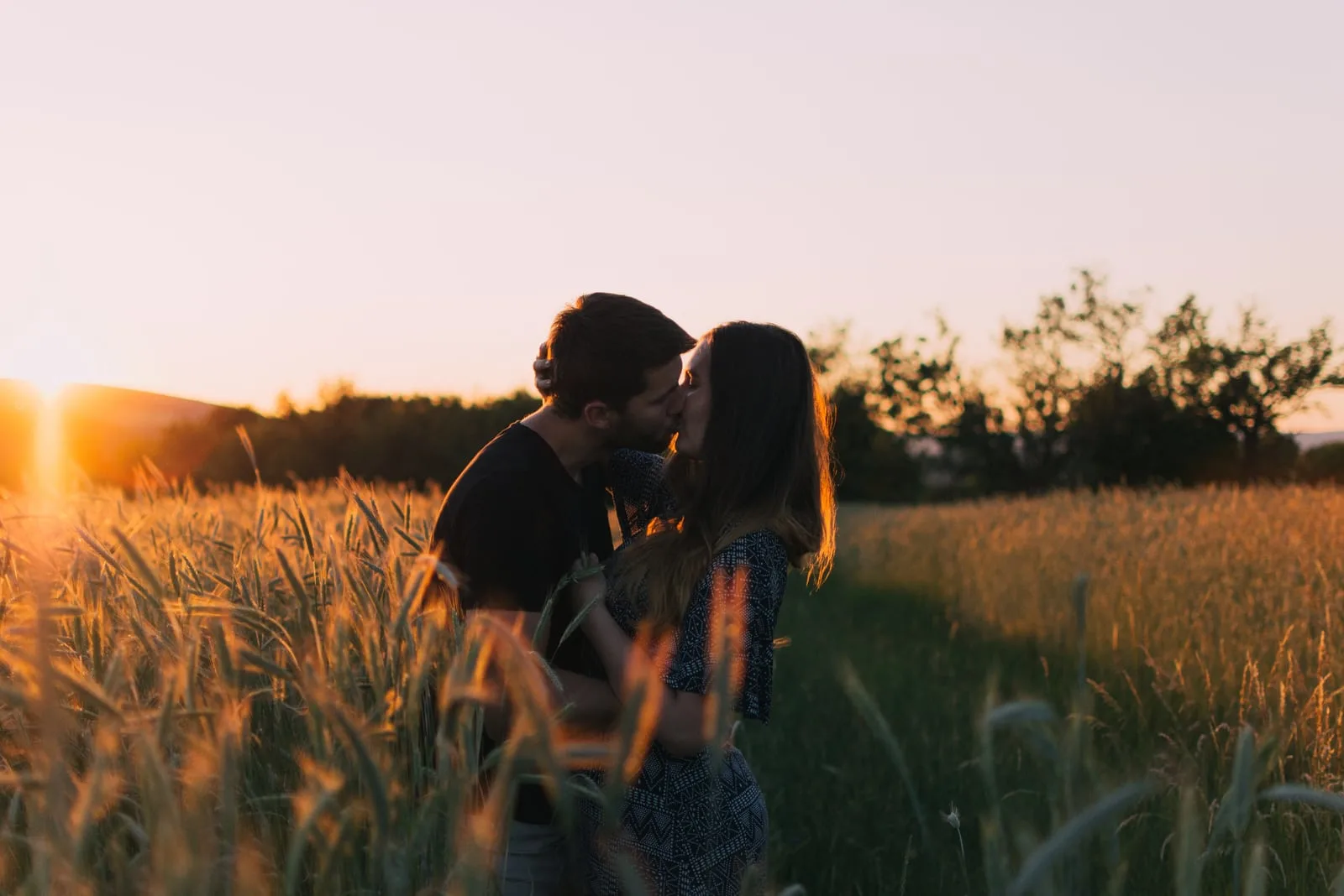 couple kissing in field