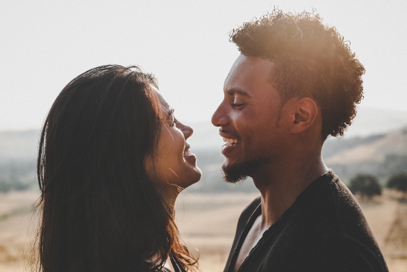 man and woman making eye contact while laughing outdoor
