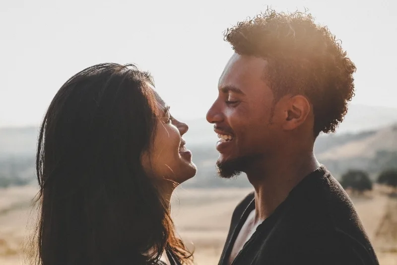 man and woman making eye contact while laughing outdoor