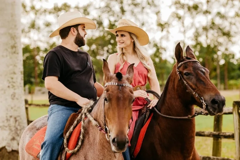 man and woman making eye contact while riding horses