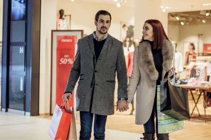 casais apaixonados de mãos dadas à saída do centro comercial