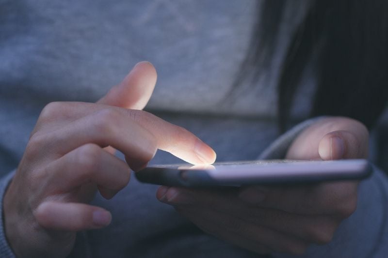 cropped image of a woman scrolling on her smartphone