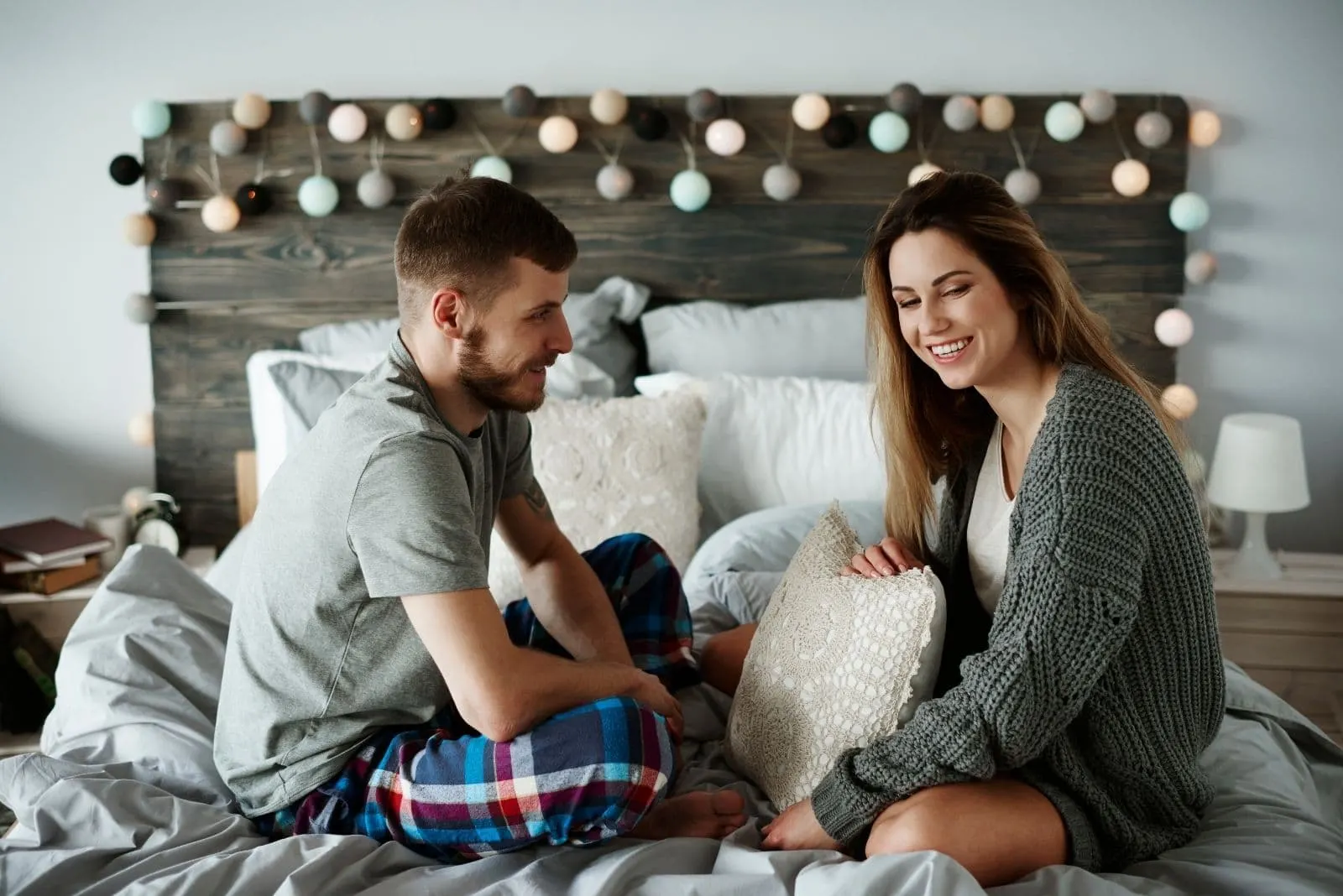 happy couple talking in bed in their pajamas