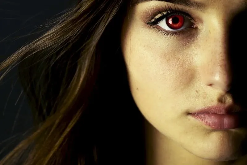 image of a beautiful young vampire woman with red eye cropped half of the face