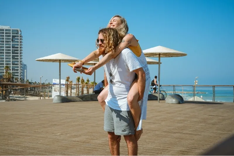 man in white t-shirt carrying woman outdoor