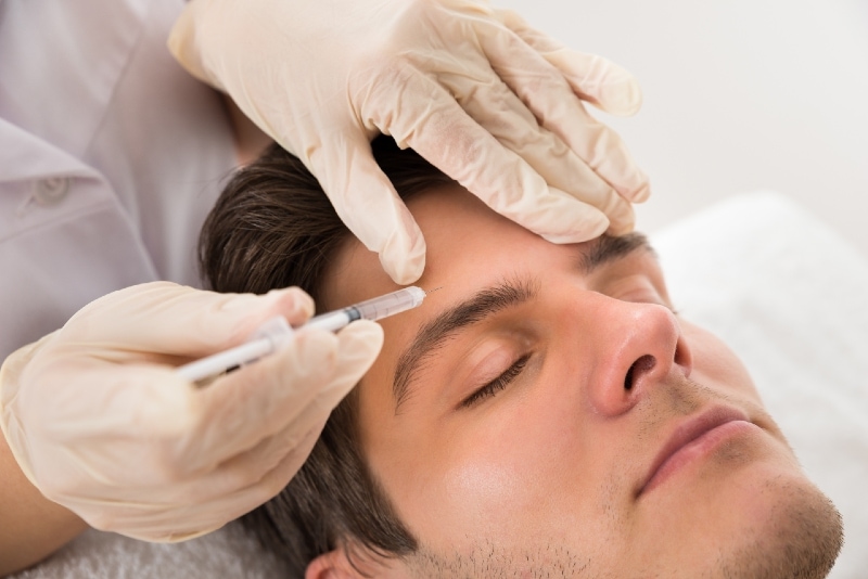 man with eyes closed having botox treatment