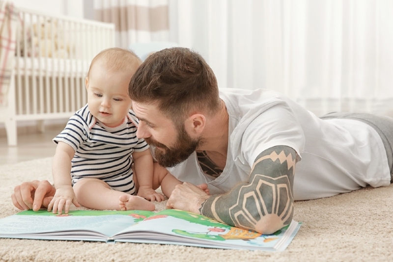 man with beard playing with baby at home