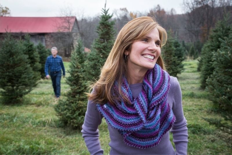 mature woman smiling outdoors during cold season wearing sweater